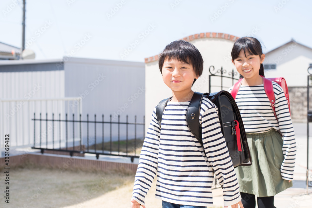 Obraz premium 家に帰る小学生の男の子と女の子