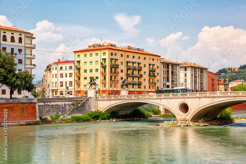 Fotografie Urban riverscape with old historic bridge and buildings, Verona, Italy