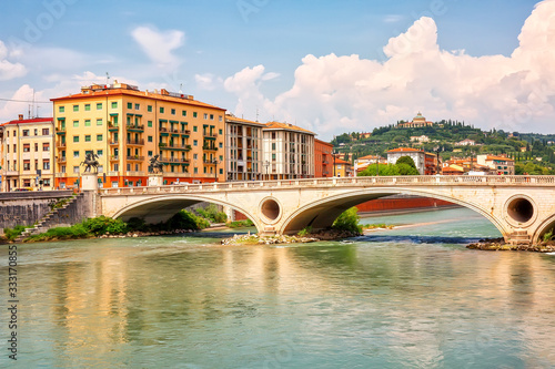 Fototapeta Urban riverscape with old historic bridge and buildings, Verona, Italy