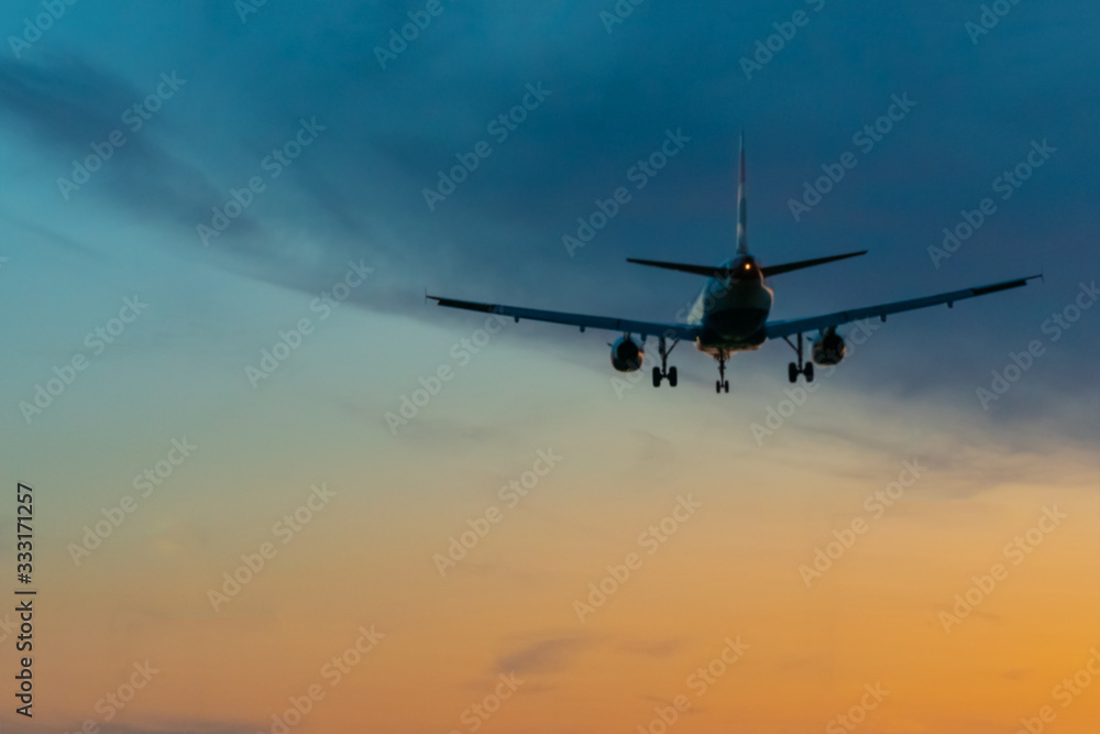 Passengers or commercial airplane flying above clouds in sunset light. Concept of fast travel holidays and business.