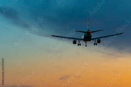 Passengers or commercial airplane flying above clouds in sunset light. Concept of fast travel holidays and business.