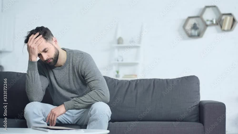 upset man with folder touching head at home upset man with folder touching head at home