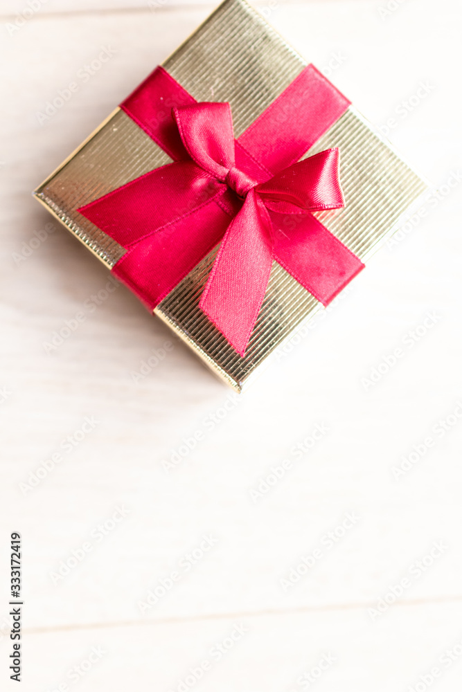 Small golden gift box with red ribbon on top. Gift for mother's day, birthday or jewellery for women. Gift box for present during special occasion Small golden gift box with red ribbon on top. Gift for mother's day, birthday or jewellery for women. Gift box for present during special occasion