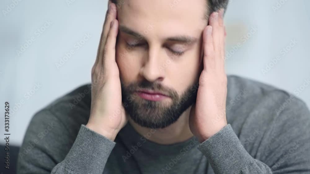 worried and bearded man touching face worried and bearded man touching face