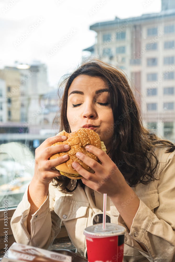Cute girl sits a cafe with fast food Cute girl sits a cafe with fast food