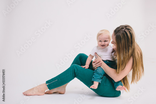 Portrait of happy mother with her little baby in her room.