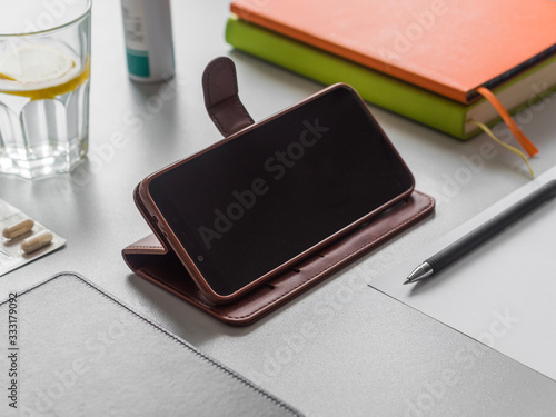 Wallpaper Mural Distance learning or work, online education concept. Workplace. Smartphone, books, glass of water with lemon and pills on the table. Phone screen mockup Torontodigital.ca