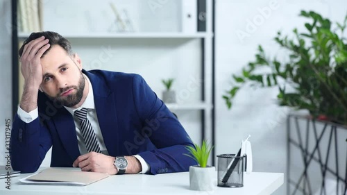 frustrated businessman in suit sitting in office photo