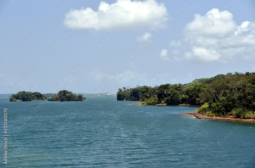 Green landscape of Panama Canal, view from the transiting cargo ship.