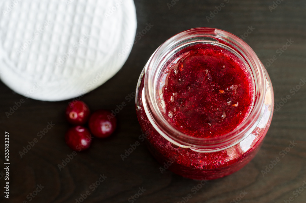 Homemade cranberry face mask (scrub) in a small glass jar. DIY cosmetics and spa recipe. top view, copy space Homemade cranberry face mask (scrub) in a small glass jar. DIY cosmetics and spa recipe. top view, copy space