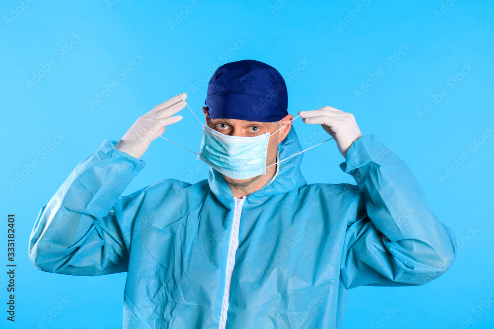 man surgeon putting on gloves. doctor putting on white sterilized surgical gloves, white background