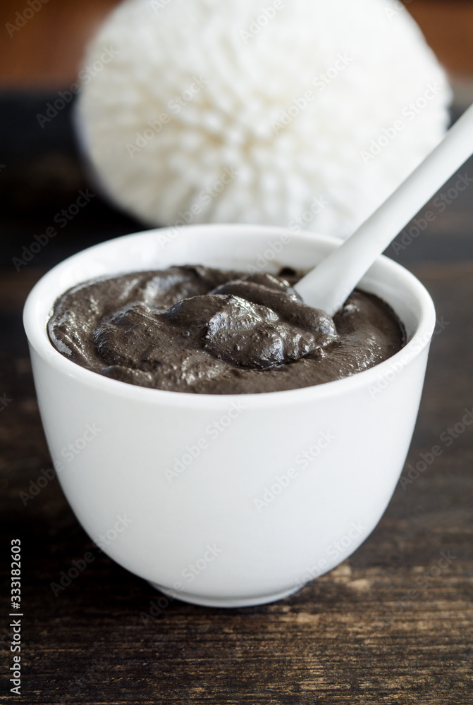 Black volcanic clay in the white bowl. Diy facial mask and body wrap recipe. Natural beauty treatment and spa. Copy space. Black volcanic clay in the white bowl. Diy facial mask and body wrap recipe. Natural beauty treatment and spa. Copy space.