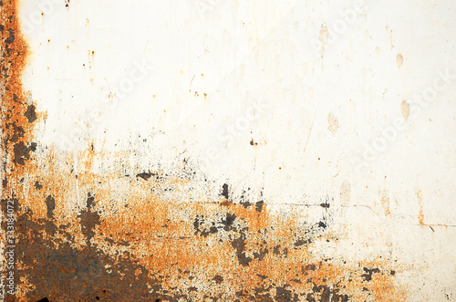 White metal door or wall close-up. Bright spots on a light background. Yellow, black and orange rusty spots on iron. Abstract urban background. Copy space. Selective focus image.