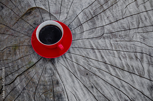 Czerwona filiżanka kawy na starym, drewnianym stole