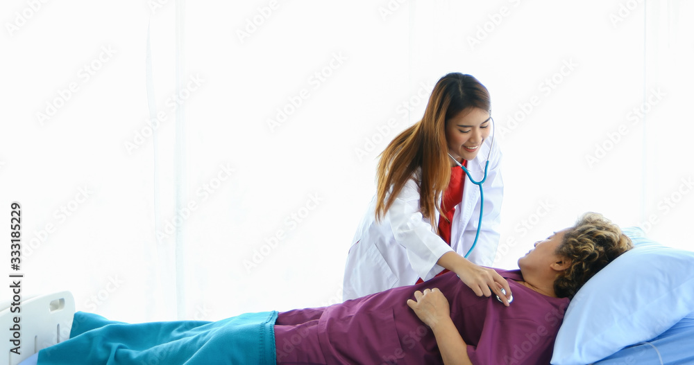 Naklejka premium The doctor used a stethoscope to check the lungs of the elderly woman at the hospital.