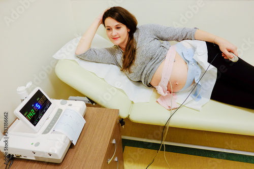 Woman at doctor office whit ctg or ecg.  Ctg pregnancy at hospital. 