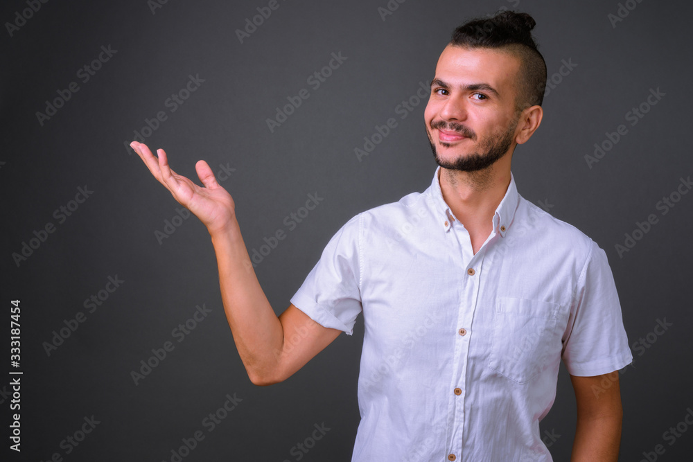 Portrait of handsome bearded Turkish man showing something Portrait of handsome bearded Turkish man showing something