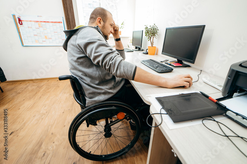 Man in wheelchair working in the office