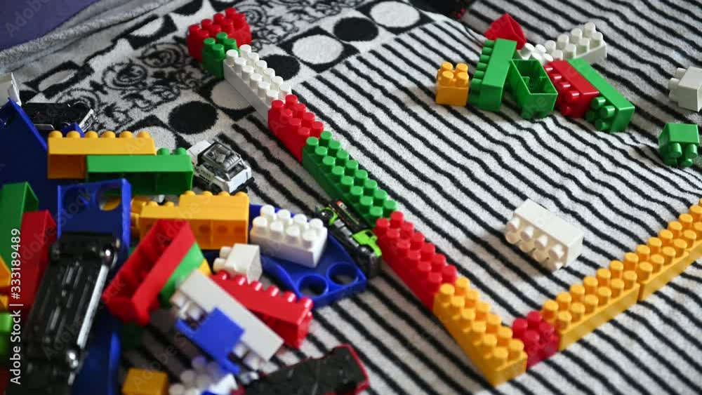 Happy child playing in the colored blocks on a striped sofa Happy child playing in the colored blocks on a striped sofa
