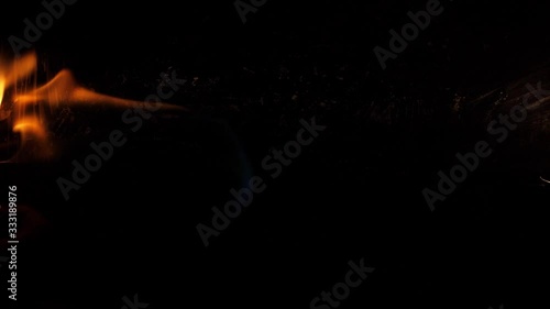 Slow motion speed closeup scene on  burning pattern rise up on black grunge floor background, fast spread of blue hot flame above fuel surface, blasting stream of fire ignite on petroleum