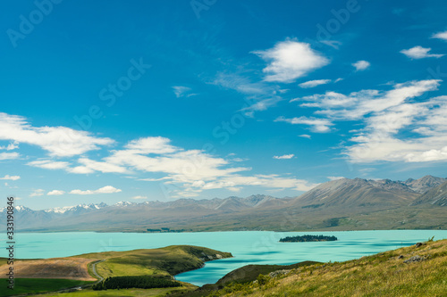 landscape with turqouise lake tekapo and blue sky in new zealand