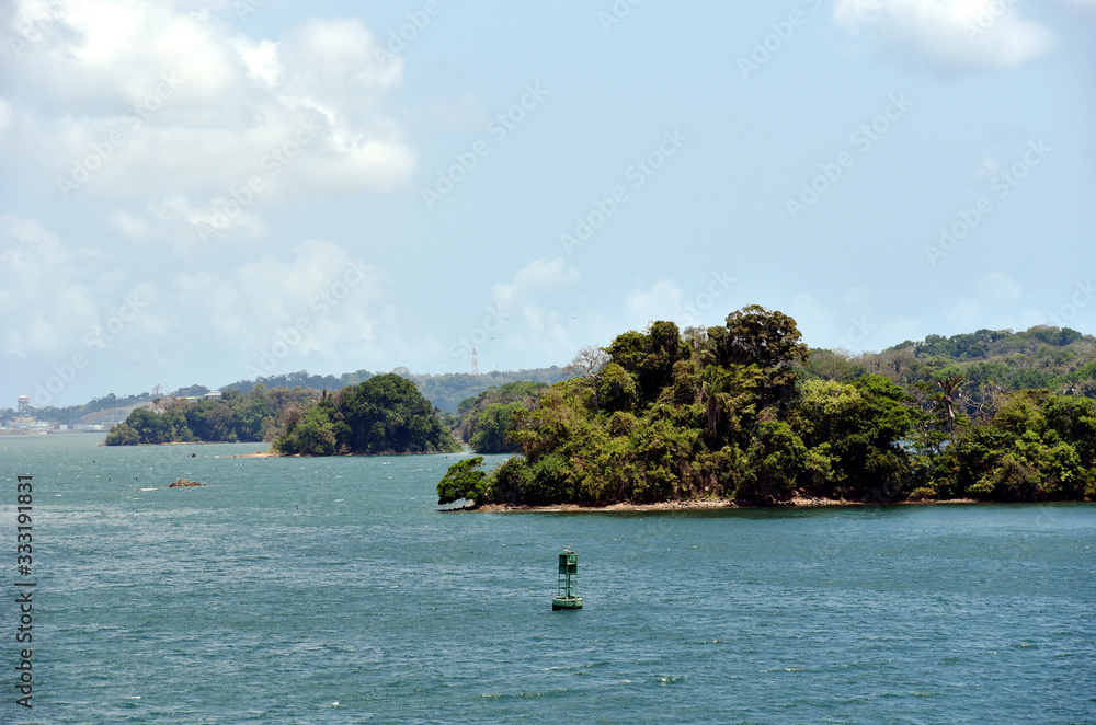 Green landscape of Panama Canal, view from the transiting cargo ship.