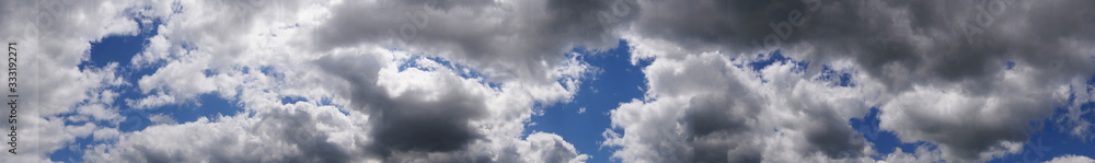 Fototapeta premium White fluffy soft clouds on a blue saturated sky on a sunny summer day