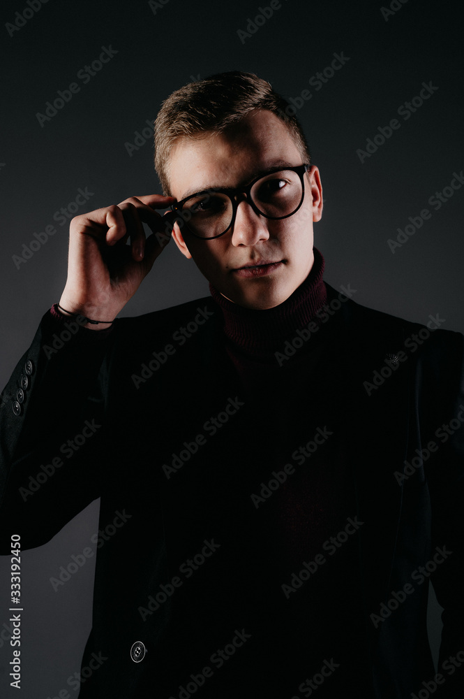 Fototapeta premium A young male journalist with glasses near a typewriter.