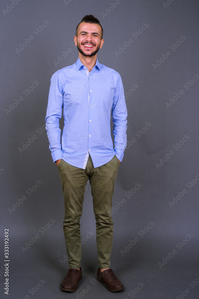 Full body shot of happy bearded Turkish businessman smiling Full body shot of happy bearded Turkish businessman smiling