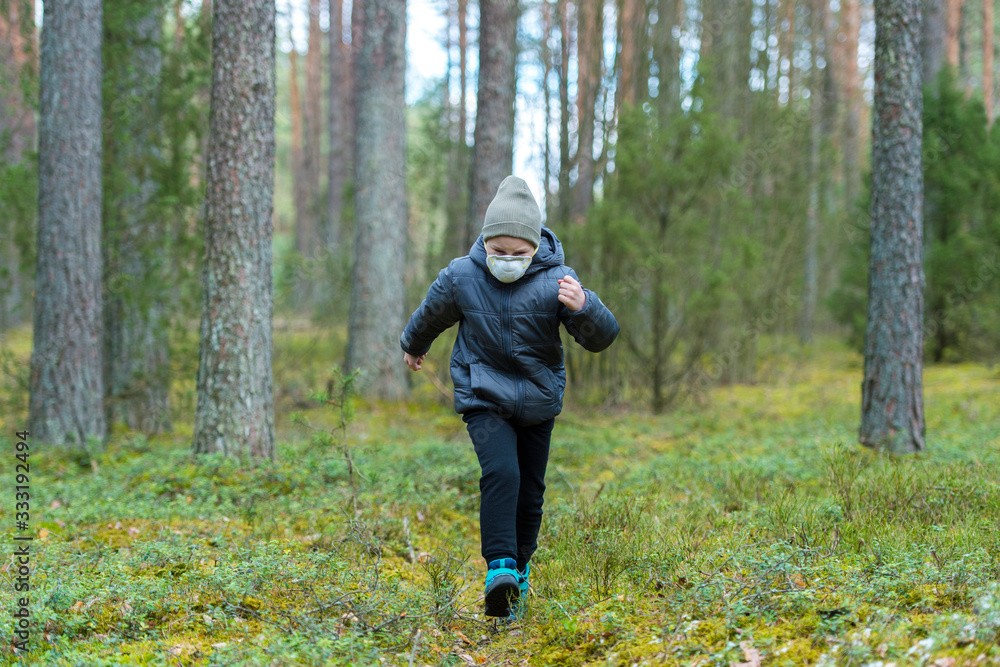 Little boy with a mask run in the forest. Corona virus quarantine Little boy with a mask run in the forest. Corona virus quarantine