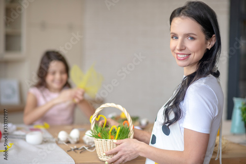 Pretty brunette woman holding easter basket in her hands
