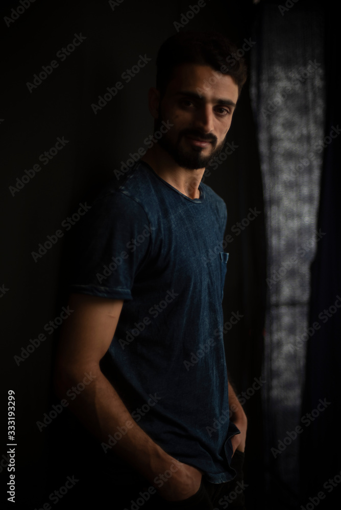 Portrait of young brunette Indian man in casual tee shirt in black background. lifestyle and fashion. Portrait of young brunette Indian man in casual tee shirt in black background. lifestyle and fashion.
