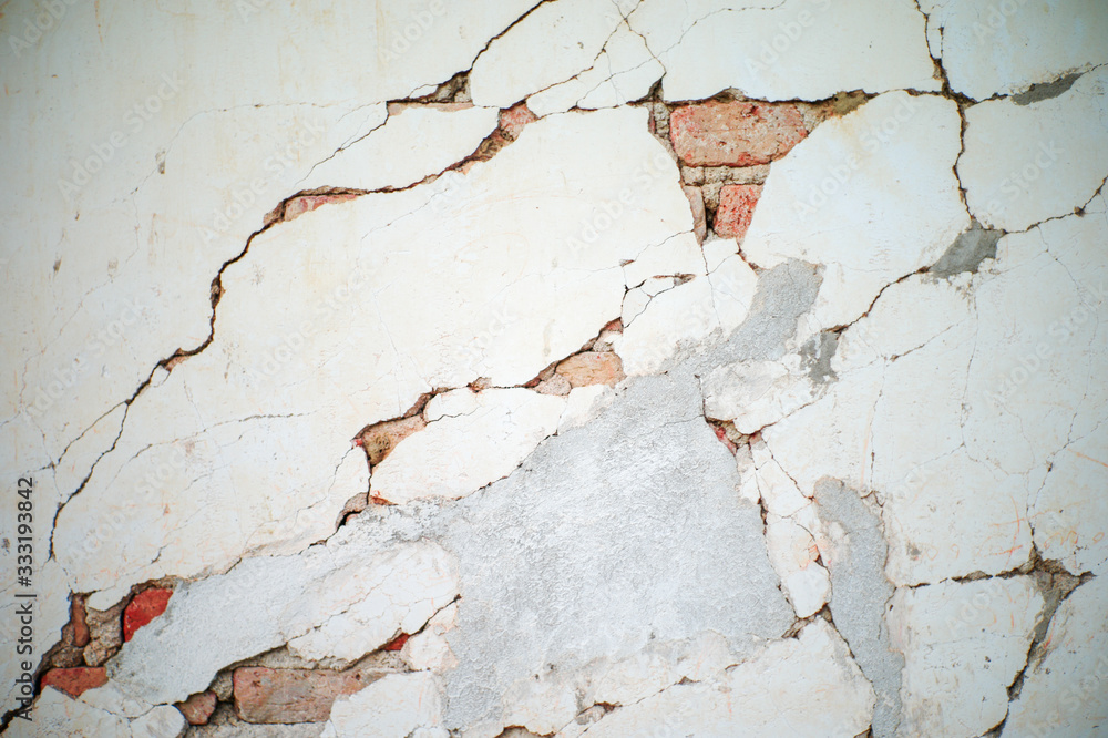 Abstract texture and background of broken plastered cement wall with red bricklayers inside