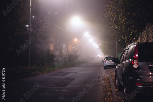 Empty foggy moody city street during night