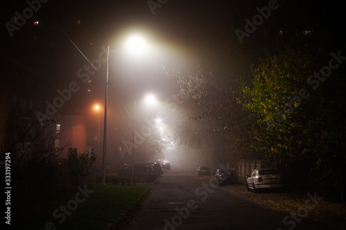 Empty foggy moody city street during night