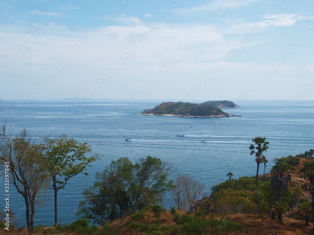  Three speedboats rush on the sea surface with hight speed. Landscape of two small islands, coast, water, horizon and palm trees. Tropical panoramic view.