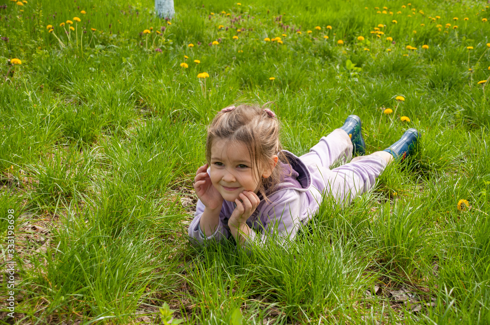 Sweet little girl take a rest on the grass in the garden