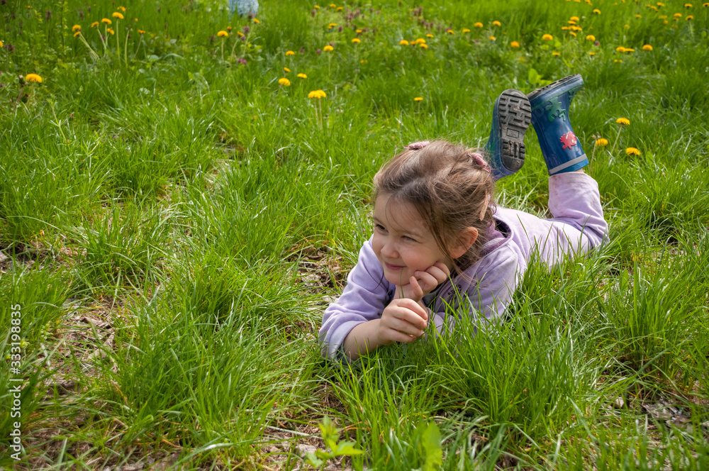 Sweet little girl take a rest on the grass in the garden