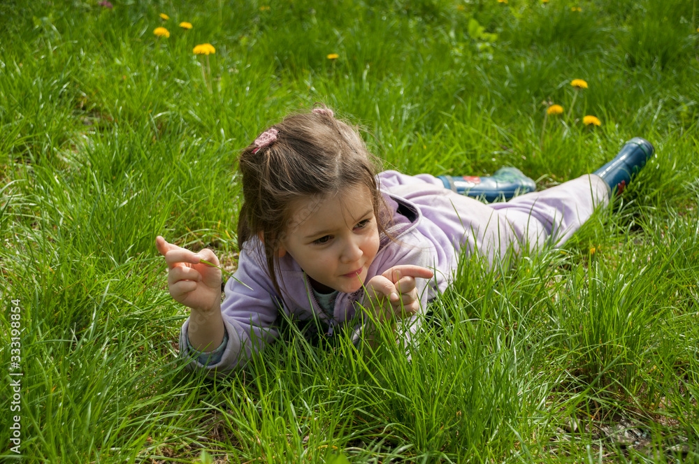 Sweet little girl take a rest on the grass in the garden