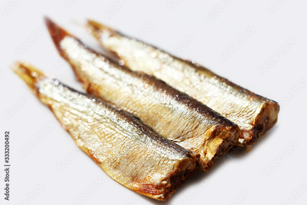 Hot smoked sprats or in oil on a white background. Small salted fish. Hot smoked sprats or in oil on a white background. Small salted fish.