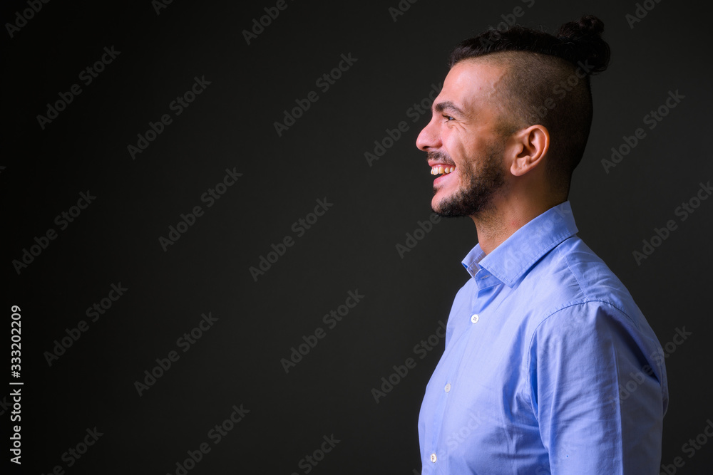 Obraz premium Closeup profile view of happy bearded Turkish businessman smiling