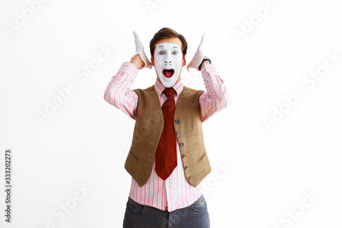 A portrait of a man, an actor, a pantomime, a man makes a panic, aggression gesture. Emotions, facial expressions, feelings, body language, signs. Image on a white studio background.