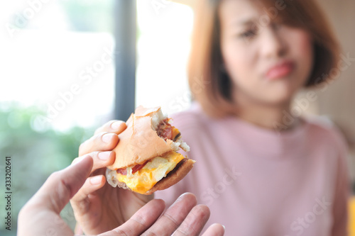 Cheese burger is heigh calories for dieting women A woman refuses cheese burger because she is controlling her calories Dieting Selective focus