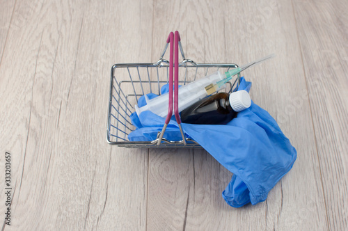 medical gloves and syringe in shopping basket on a blue background. Coronavirus, flu virus outbreak, epidemic panic, pandemic