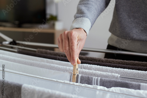 man hanging clothes on a drying rack photo