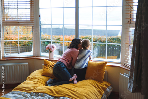 mother kissing daughter at home
