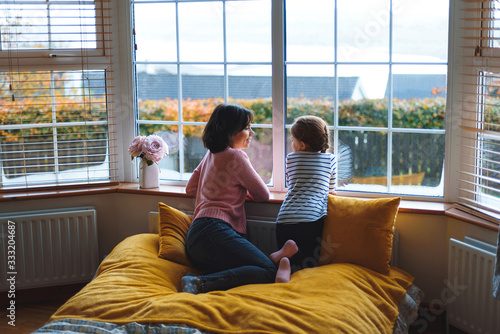 mother and daughter talking at window