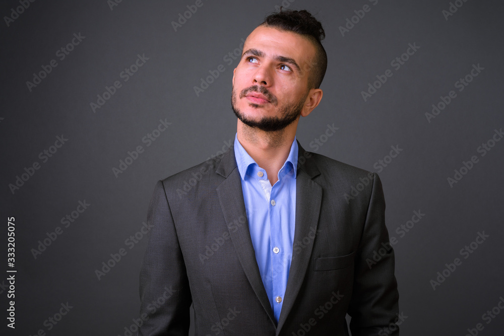 Portrait of handsome bearded Turkish businessman in suit thinking Portrait of handsome bearded Turkish businessman in suit thinking