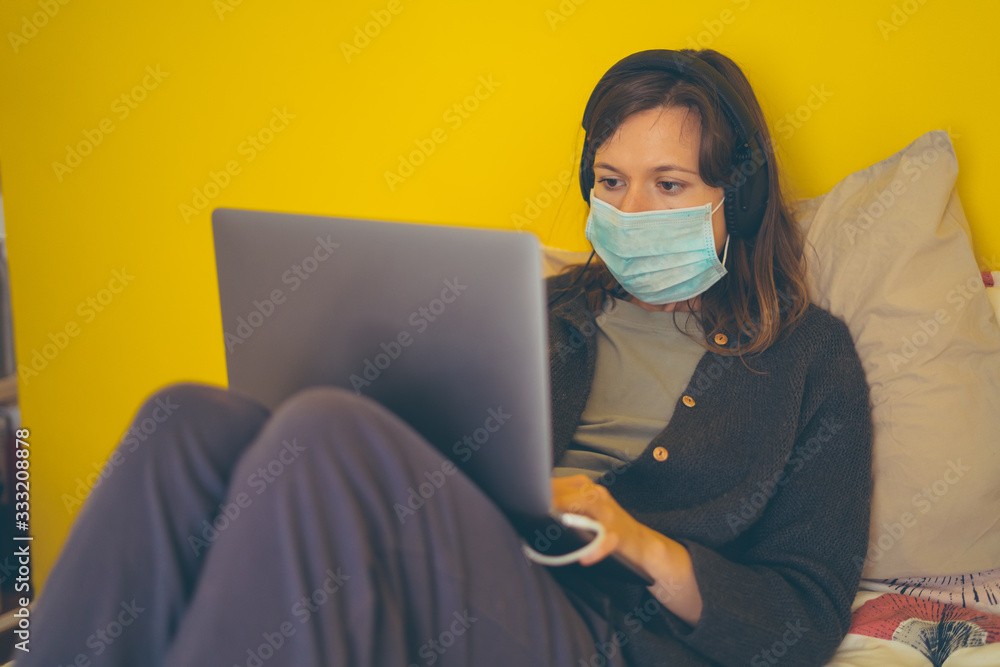 A white girl is working from home during Coronavirus or Covid-19 quarantine, coronavirus covid 19 infected patient in coronavirus covid 19 quarantine room using computer A white girl is working from home during Coronavirus or Covid-19 quarantine, coronavirus covid 19 infected patient in coronavirus covid 19 quarantine room using computer