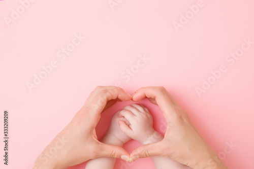 Fotomurale Heart shape created from young mother hands